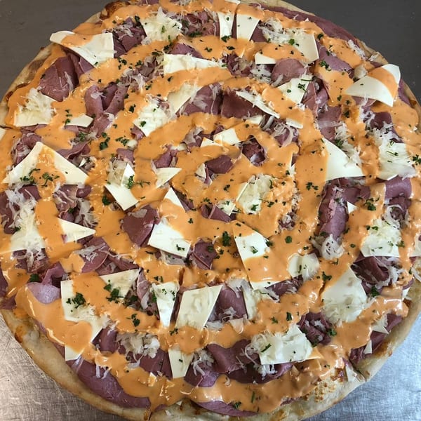Valentino's Pizzeria's Reuben pizza, topped with corned beef, sauerkraut, Swiss cheese, and Thousand Island dressing.